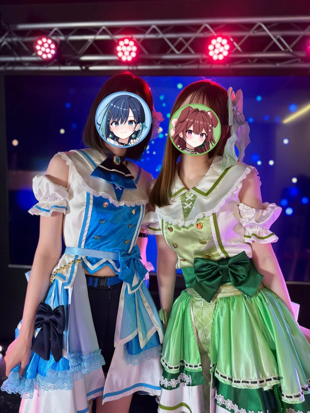 ステージ上でカラフルな衣装を着用した2人の女性が立っている