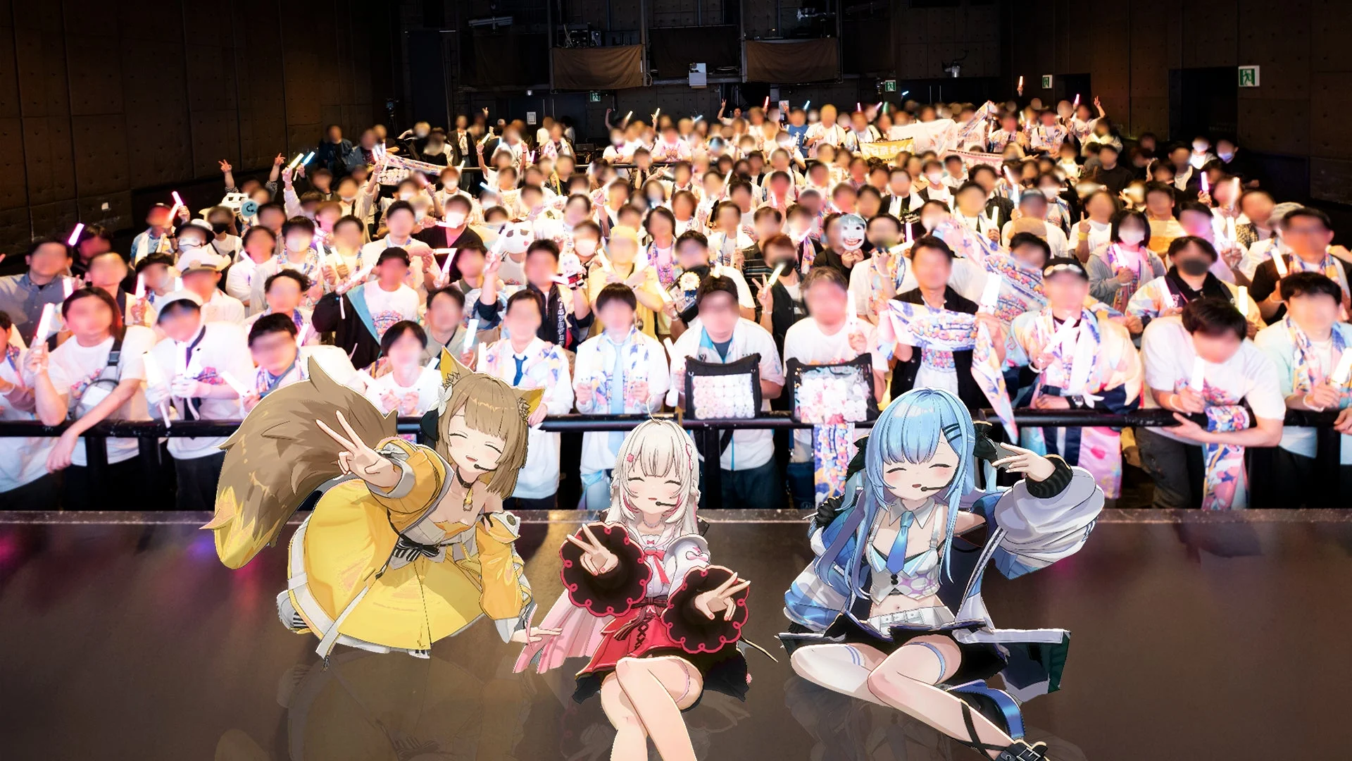 ステージ上でパフォーマンスする3人のVTuberキャラクターとサイリウムを持つ観客